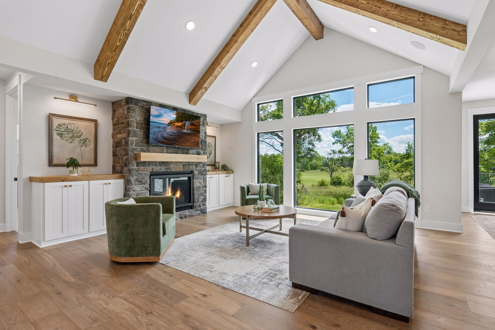 Stone fireplace feature wall with vaulted ceiling and exposed beams